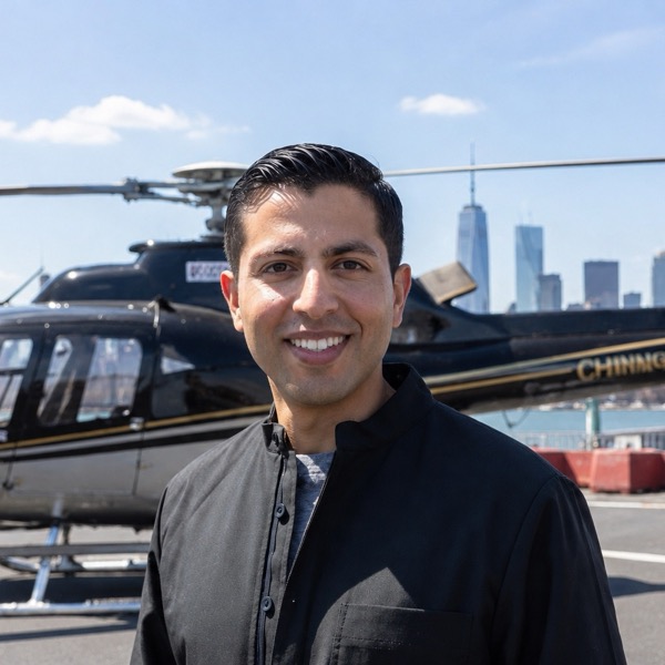 Michael Torres, New York helicopter tour specialist, in front of a helicopter with the Manhattan skyline behind